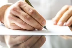 Man doing a legal document translation on a blank paper with ink pen.
