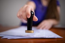 A person putting a seal on a legal document